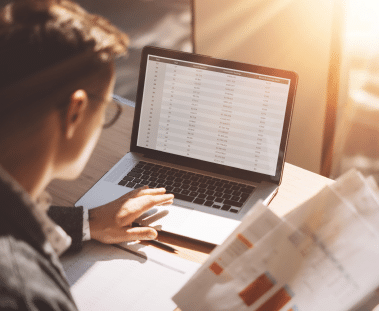 An analyst looking at data on a computer screen.